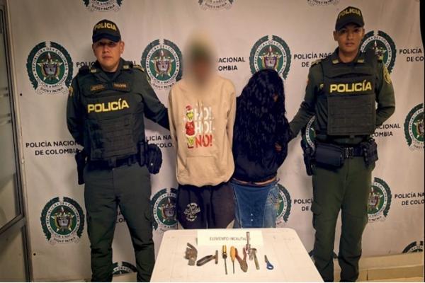 Dos funcionarios policiales y dos capturados en el centro de la fotograf&iacute;a 