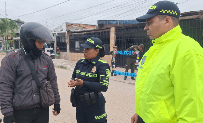 Funcionarios de la Policía Nacional realizan una orientación preventiva a una persona de civil que lleva casco