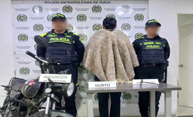 Dos policias con un capturado y motocicleta recuperada