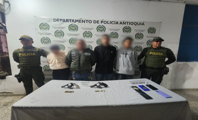 Dos policías custodian a cuatro capturados