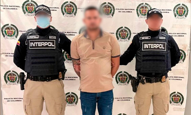 Dos funcionarios de Interpol sosteniendo al capturado alias "Virolo"