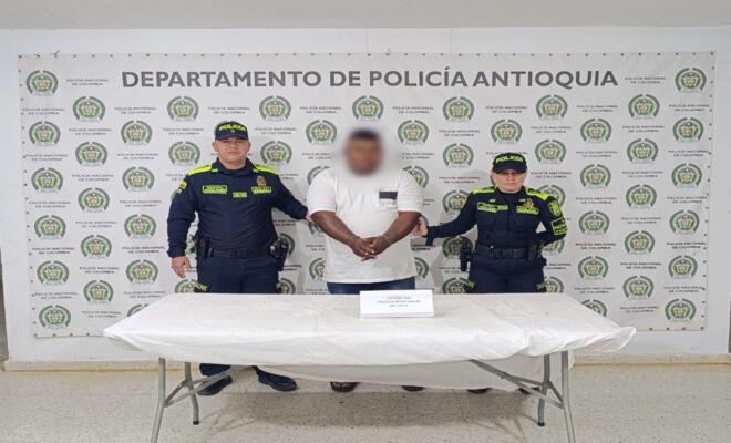 Dos policías custodian a un capturado