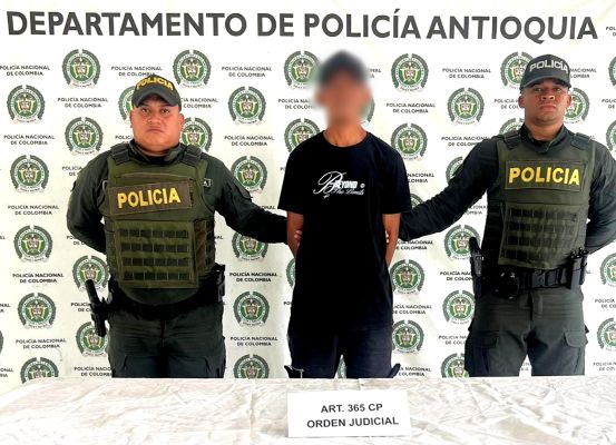 Dos policias con una persona capturada