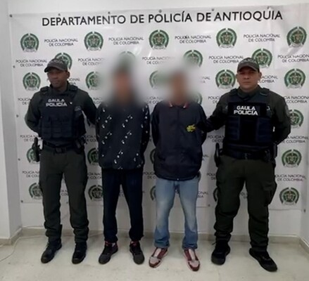 Dos polic&iacute;as del GAULA custodian a dos capturados por extorsi&oacute;n