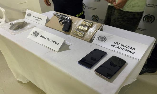 Elementos incautados: arma, munici&oacute;n, sustancia y celulares sobre una mesa.