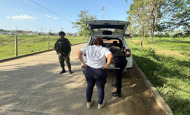 Dos funcionarios policiales realizando un registro al vehículo de una ciudadana