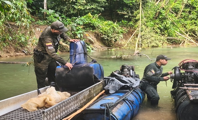 Policías destruyendo maquinaria de explotación Minera 