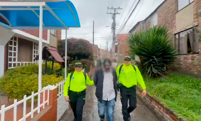 Dos policías se desplazan con un capturado.