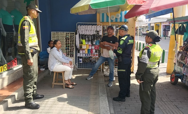 Tres funcionarios policiales dialogando con la comunidad