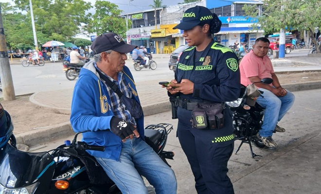 Una funcionaria policial dialogando con un ciudadano en vía pública