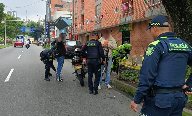 Tres policías realizando puesto de control y registros a persona