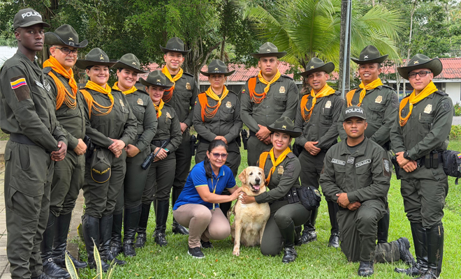 Funcionarios de Carabineros posan agrupados en el centro, acompa&ntilde;ando a la adoptante de la canina Luna.
