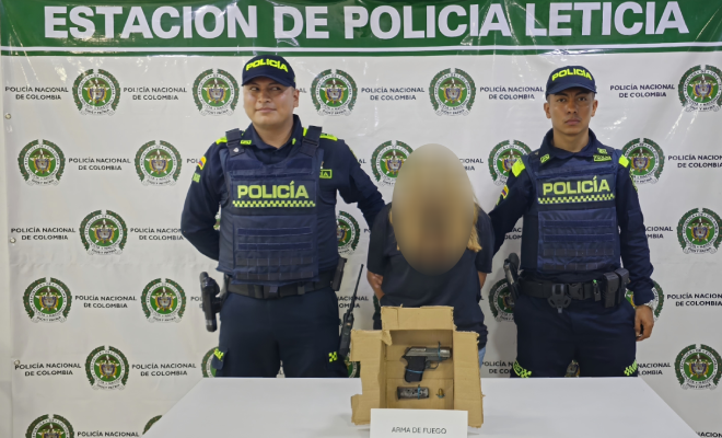 Dos_policías_una_ciudadana capturada,_encima de una_mesa_una_pistola incautada