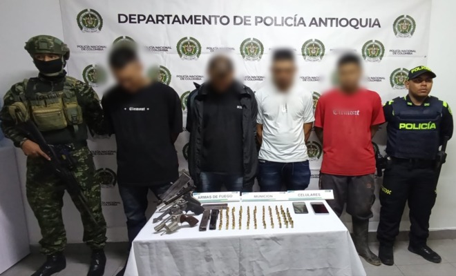 Dos policías custodian a cuatro capturados