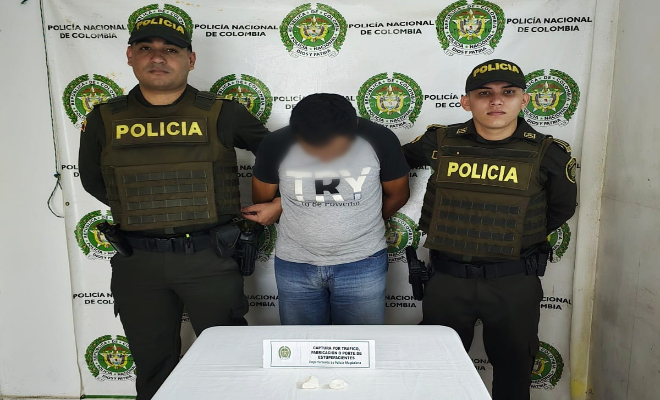 Dos policías y un capturado junto a el material incautado