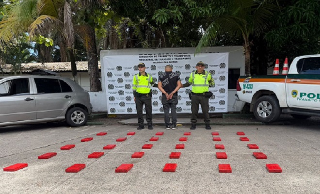 Hombre capturado por el delito de tráfico, fabricación o porte de estupefacientes sujetado por dos funcionarios de la Policía Nacional de la seccional de tránsito y transporte y el material incautado 