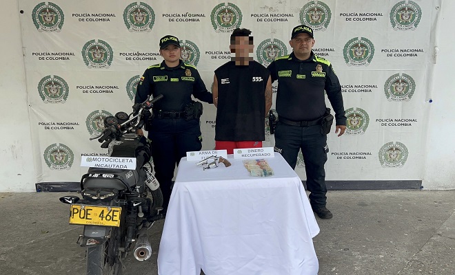 Dos policías con un capturado y una motocicleta incautada