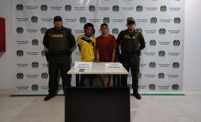 Dos policías con  dos personas Capturadas