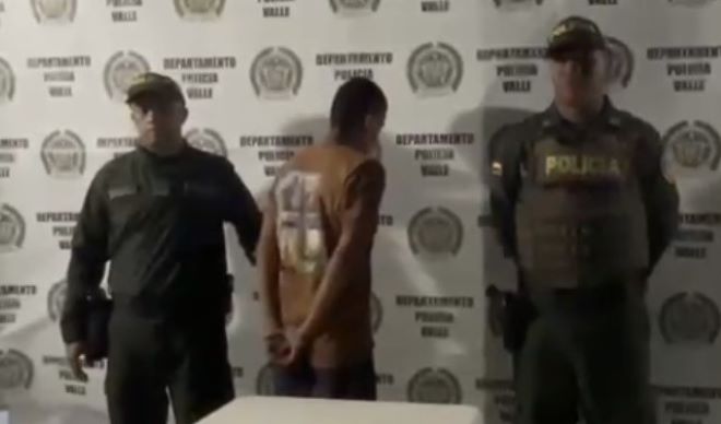 Dos policías al lado de un hombre capturado