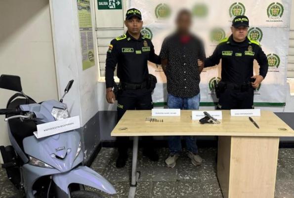 Dos polic&iacute;as al lado de un hombre capturado por hurto