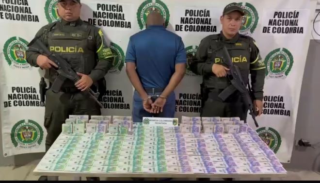 Dos policías al lado de un hombre con efectivo 