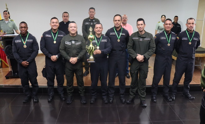 Uniformados de la Policía Nacional reciben medallas y un trofeo durante un reconocimiento institucional.
