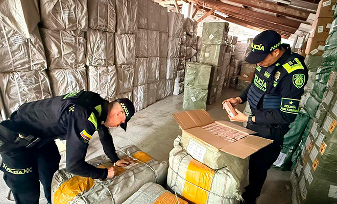 Dos policias revisando mercancias incautadas