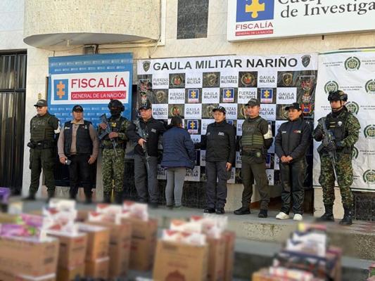 polic&iacute;as ejercito y funcionarios del CTI custodiando mercanc&iacute;a incautada y a una persona capturada