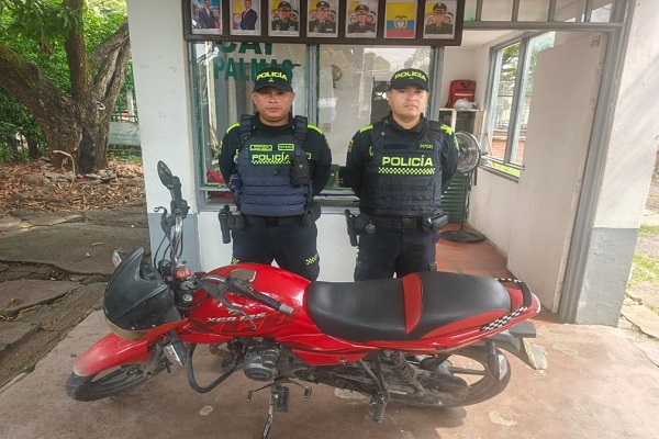 Dos polic&iacute;as con una de las motocicletas recuperadas