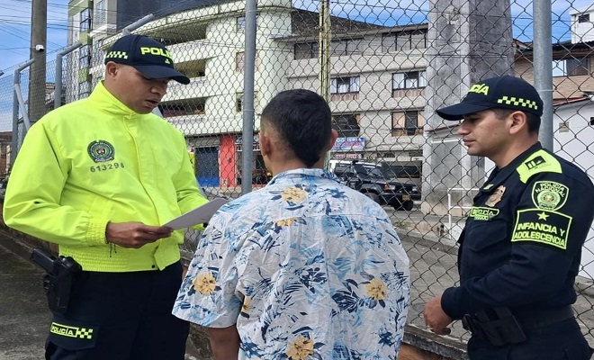 En la imagen se muestra a dos policias leyendo los derechos del capturado a un ciudadano que intento incendiar una vivienda
