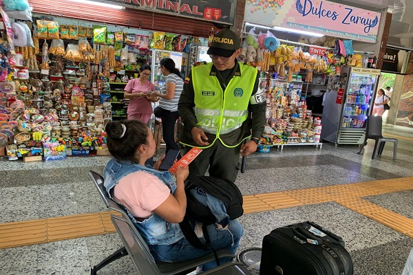 Policía compartiendo folleto informativo a una ciudadana