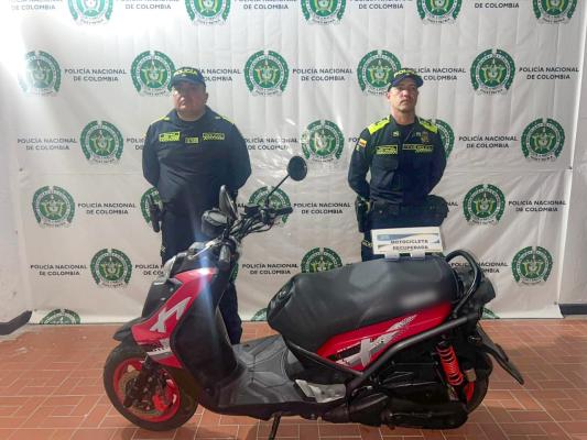 Dos Polic&iacute;as, en frente motocicleta recupedrada 