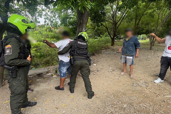 Policías realiza registro a persona a un ciudadano mientras que otro policía presta la seguridad