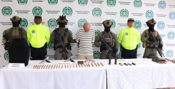 seis policías al lado de un hombre capturado con material incautado