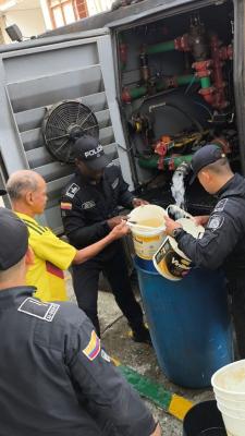 tres policías al lado de un ciudadano brindándoles agua potable
